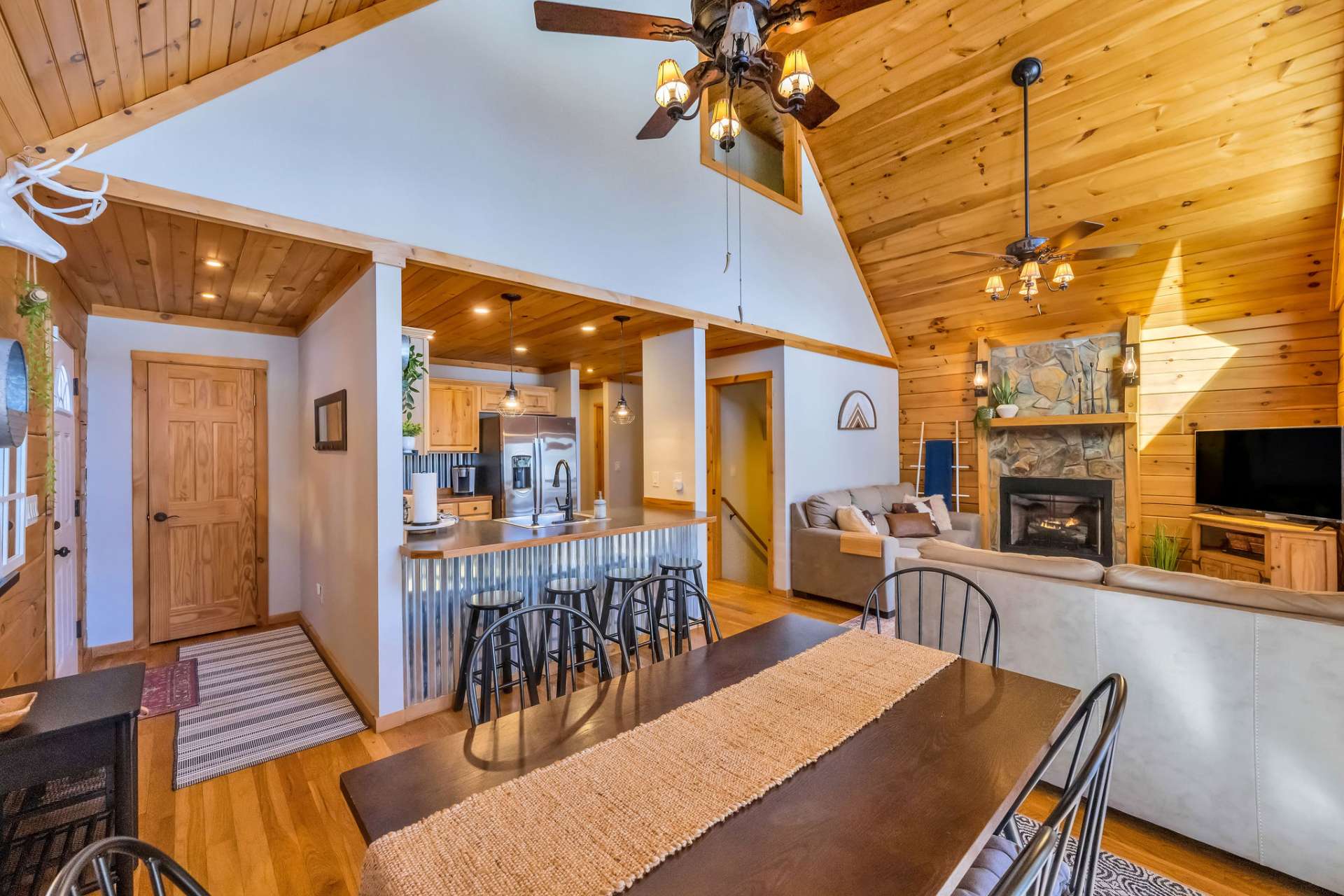 The open-concept main level boasts a stylish kitchen, a dining area, and a cozy living room with a stone fireplace.