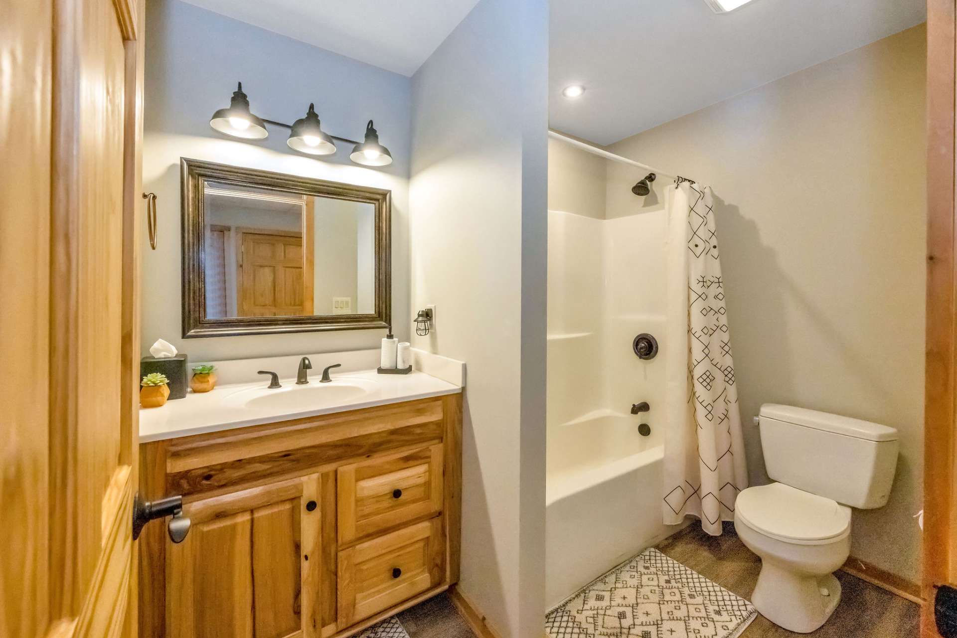 The lower-level bath offers convenience and functionality, thoughtfully designed to accommodate guests and complement the living and entertainment spaces.