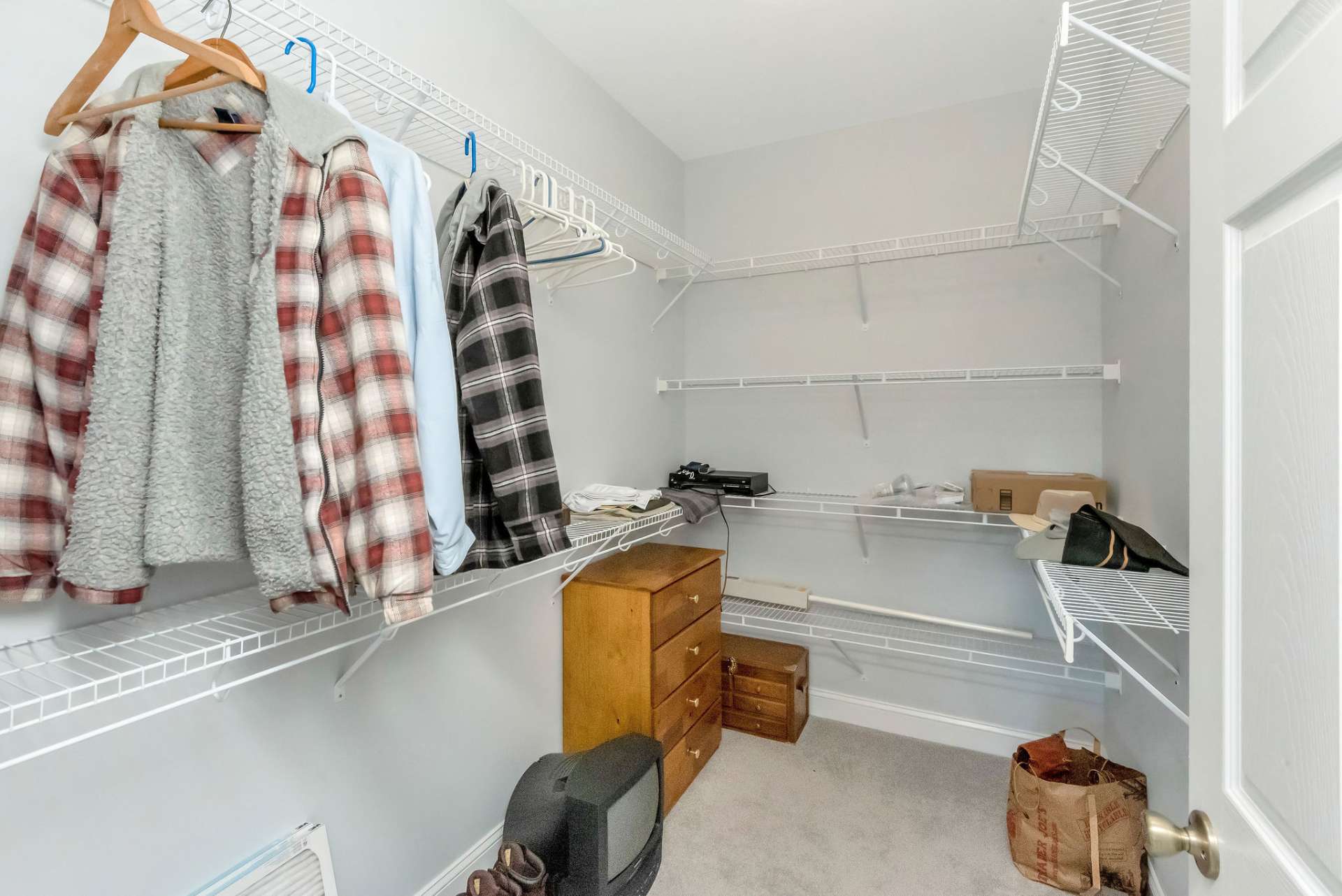 The walk-in closet is thoughtfully designed with built-in shelving, providing ample space to organize and showcase all your attire.