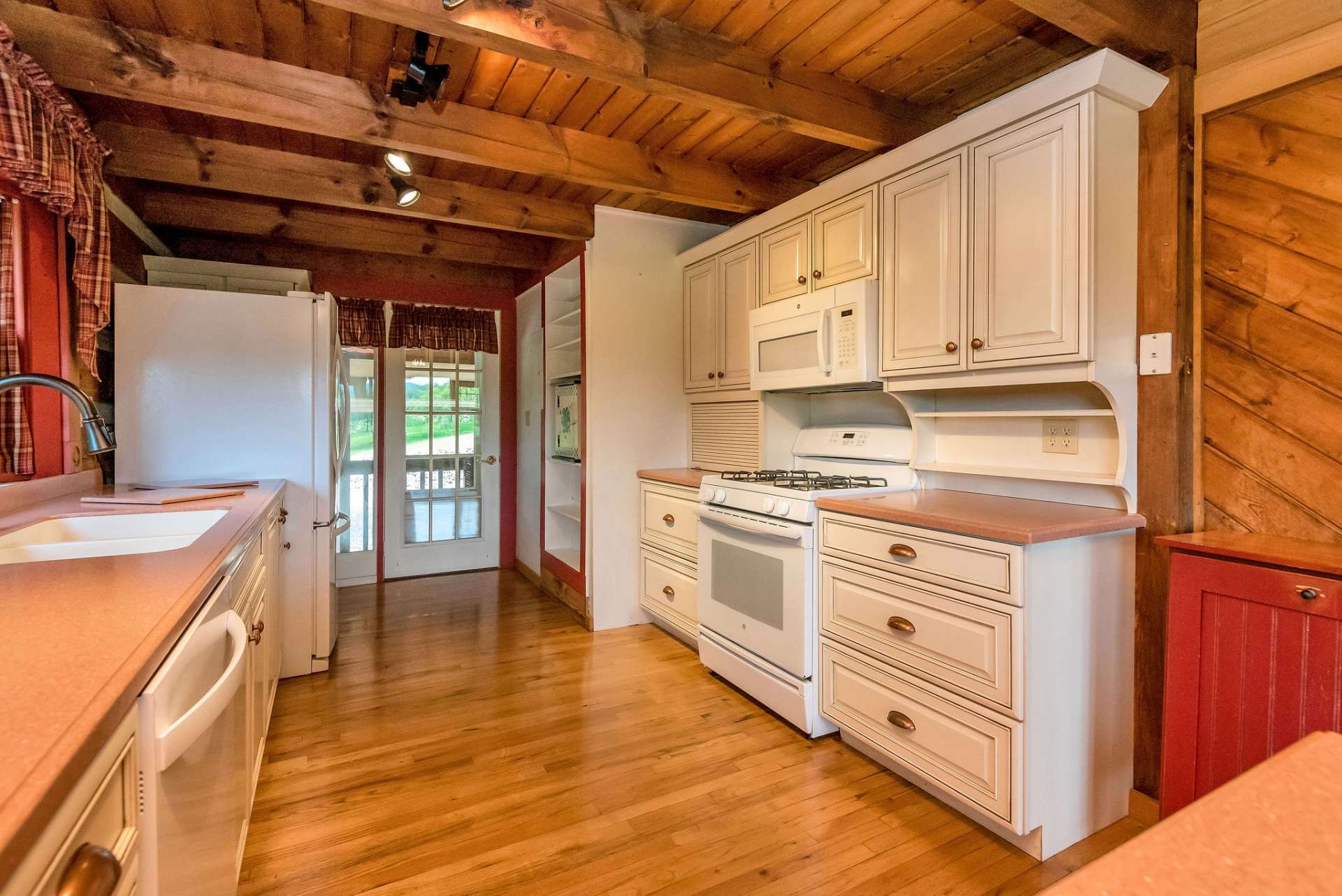 The kitchen cabinets, in a soothing cream color, further brighten up the space, adding to its inviting ambiance. Enjoy the convenience of cooking with a gas range, perfect for culinary enthusiasts.