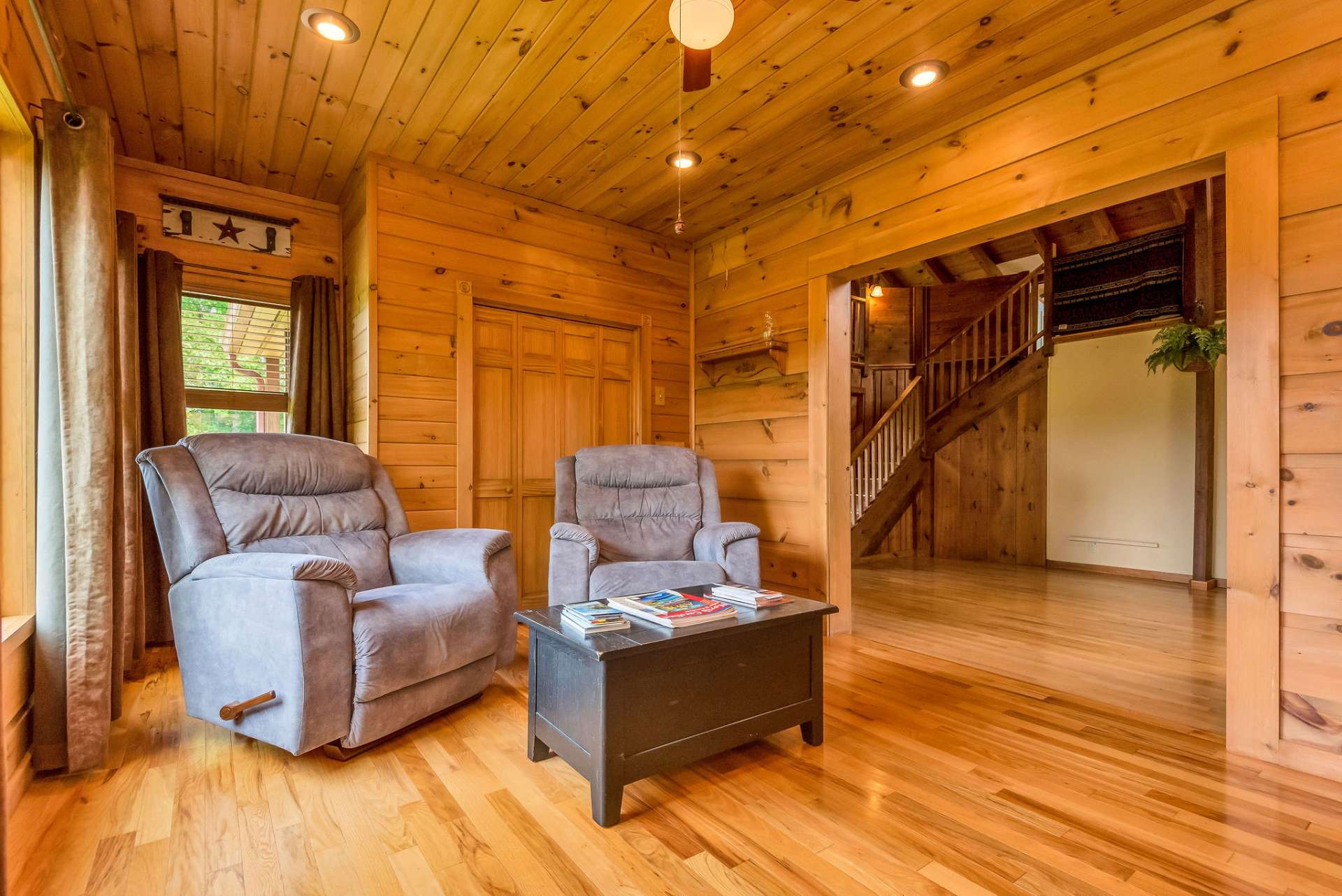 Warm wood tones envelop the den from floor to ceiling, creating a cozy and inviting atmosphere.