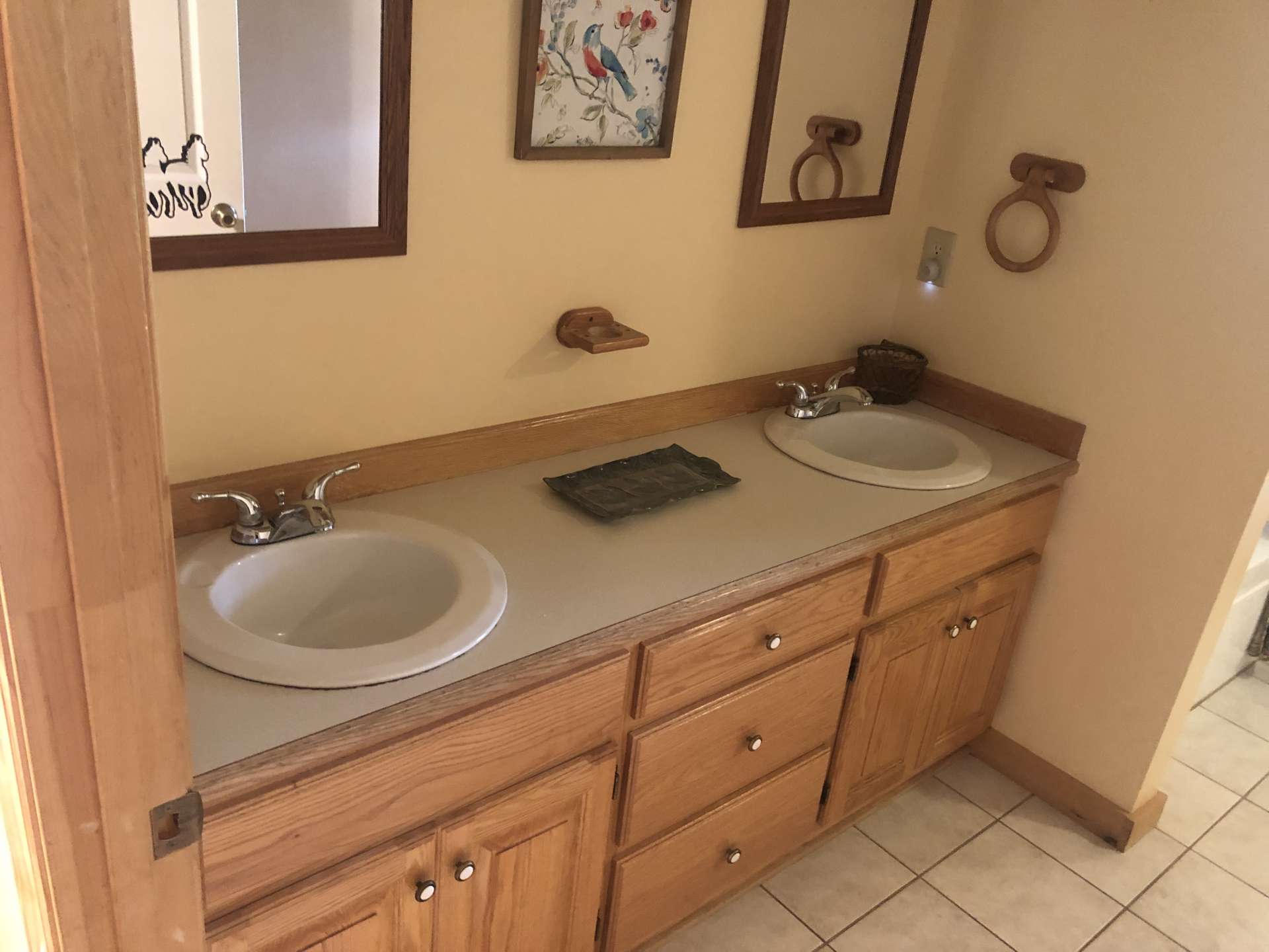 Main level bath has oak double sinks with drawer storage