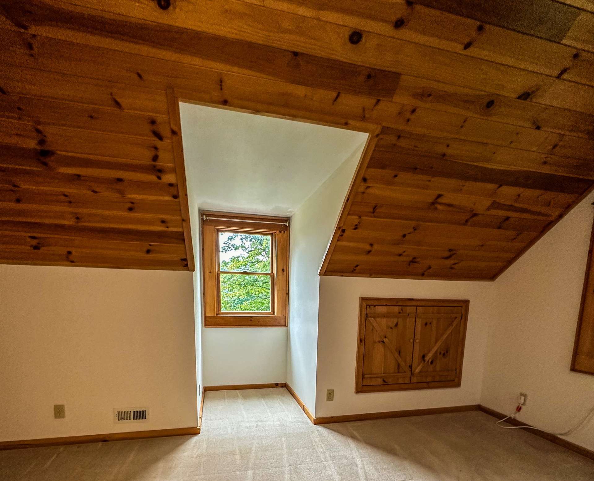 Primary bedroom on the second level which has additional built in attic storage in the eves