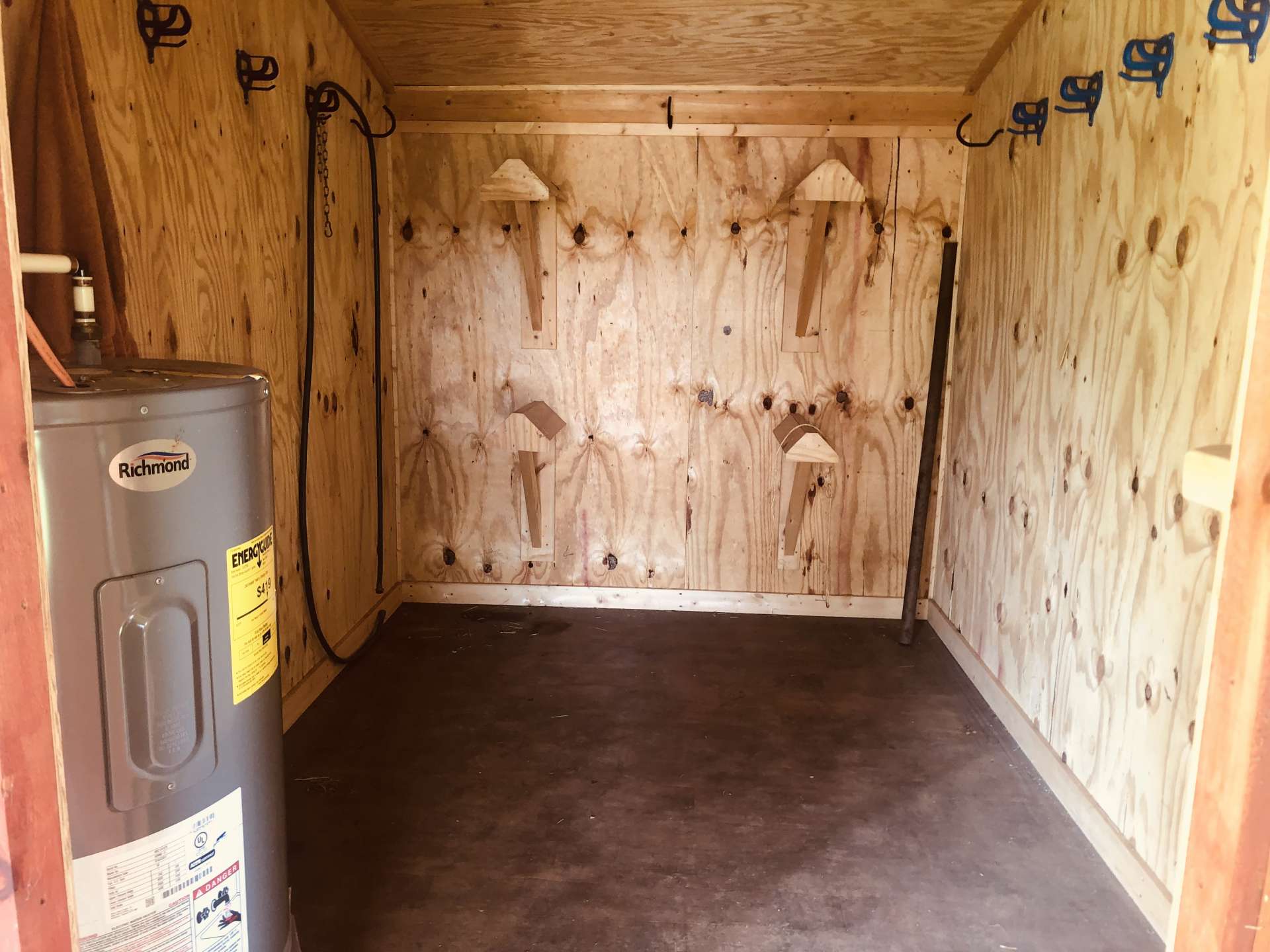 Tack room with hot water heater bridle hangers and saddle racks