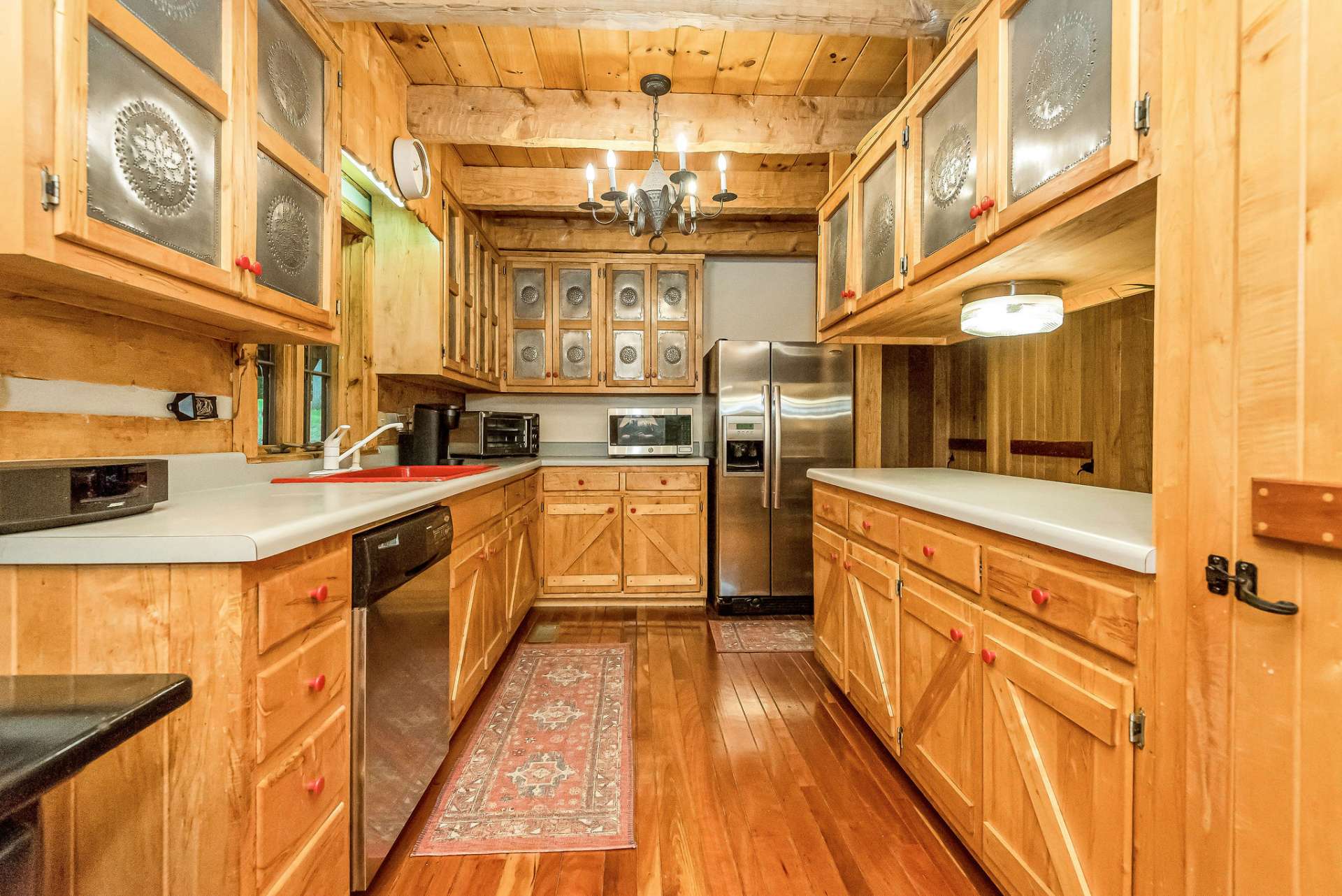 The kitchen boasts custom-built cabinetry with charming punched tin doors, adding a touch of rustic elegance to the space.