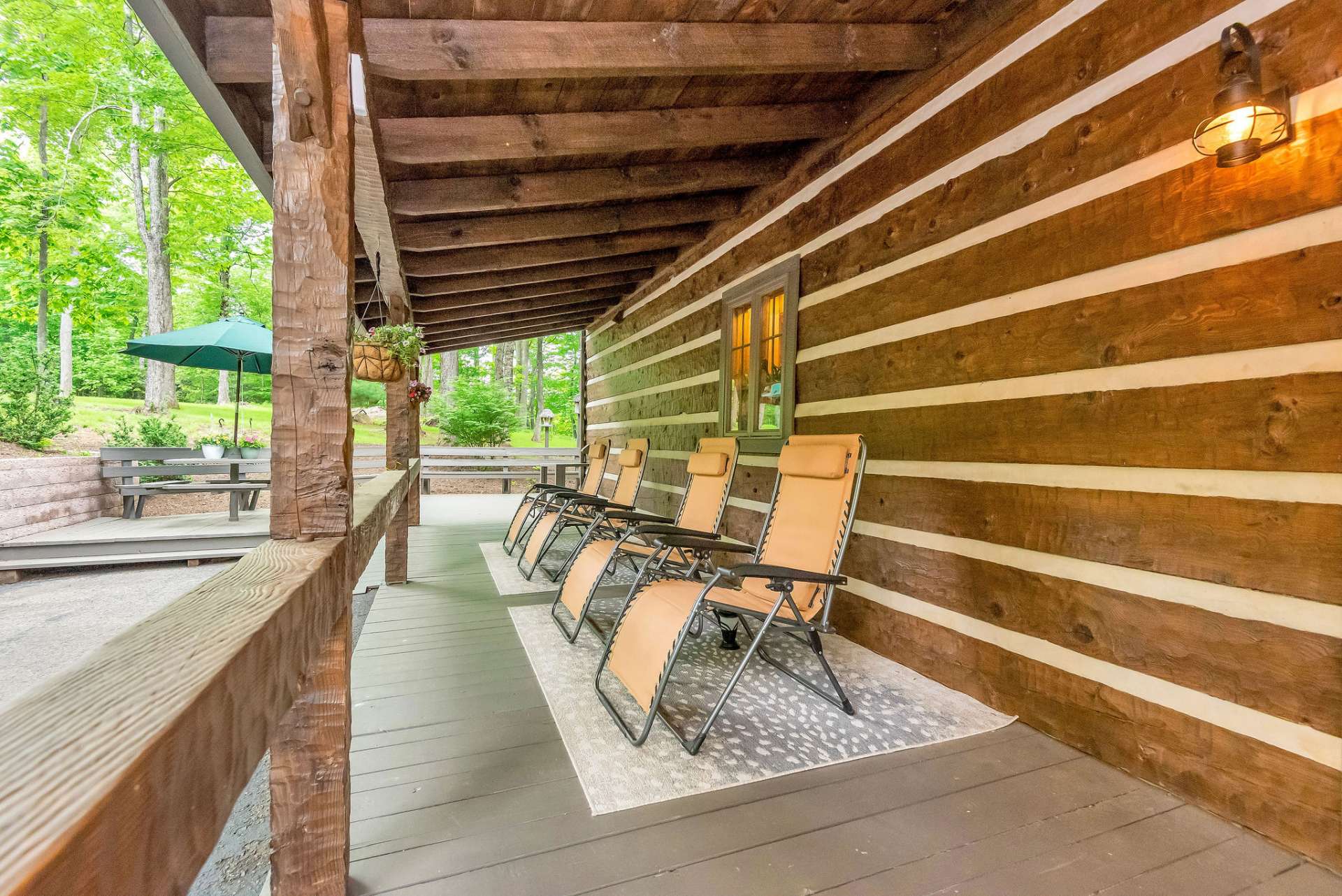 The covered back porch provides total privacy and a serene view into the wooded acreage behind the cabin.