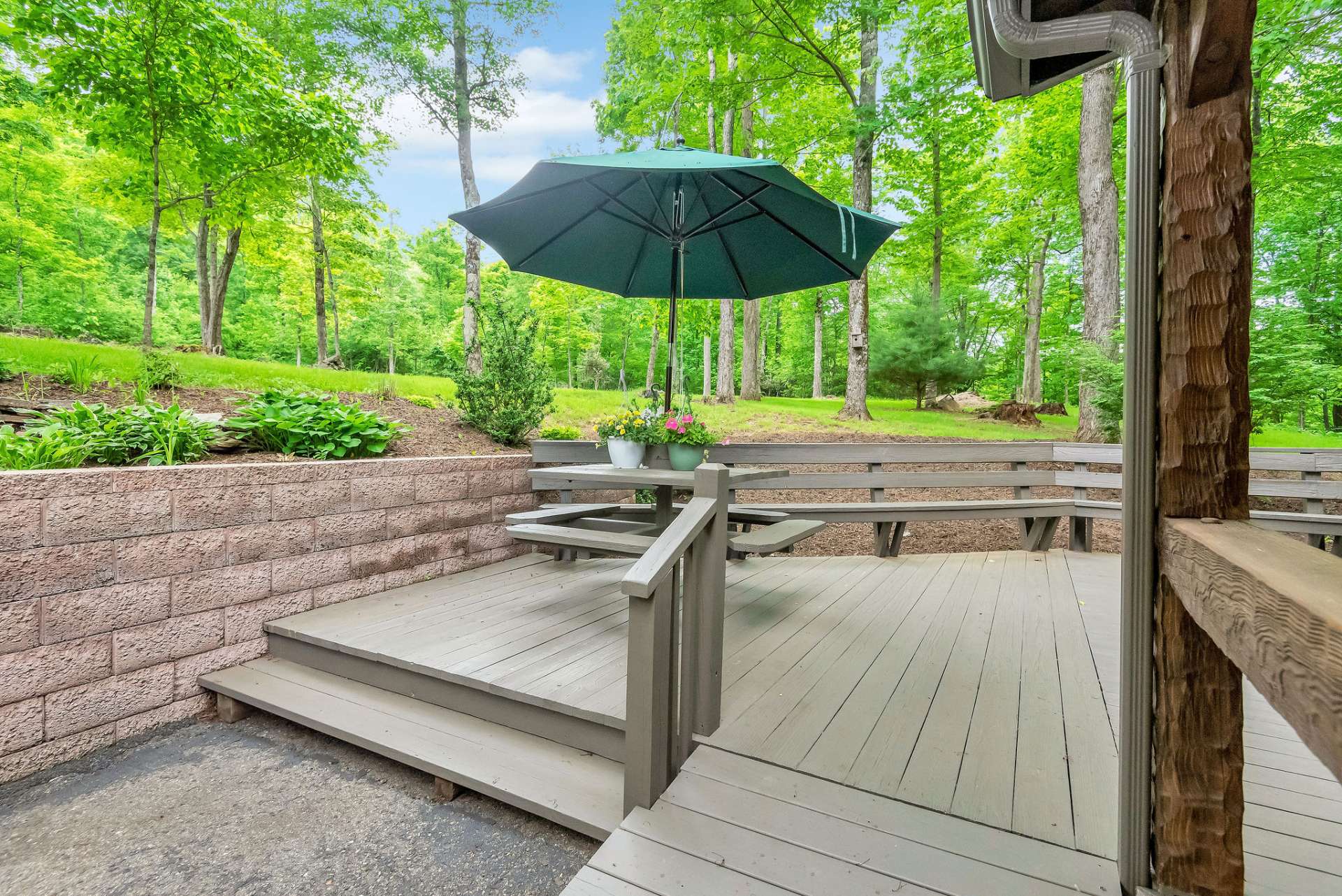 The covered back porch seamlessly transitions to an expanded open deck, complete with a built-in picnic table and bench seating.