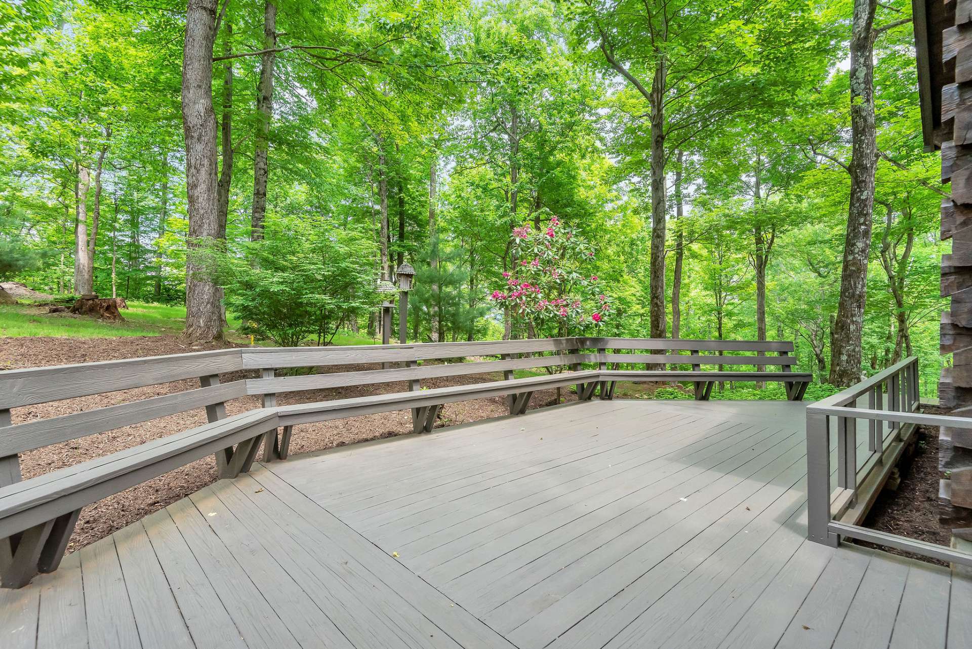 This thoughtfully designed outdoor space offers plenty of room for relaxation and entertainment, surrounded by the natural beauty of the wooded acreage.