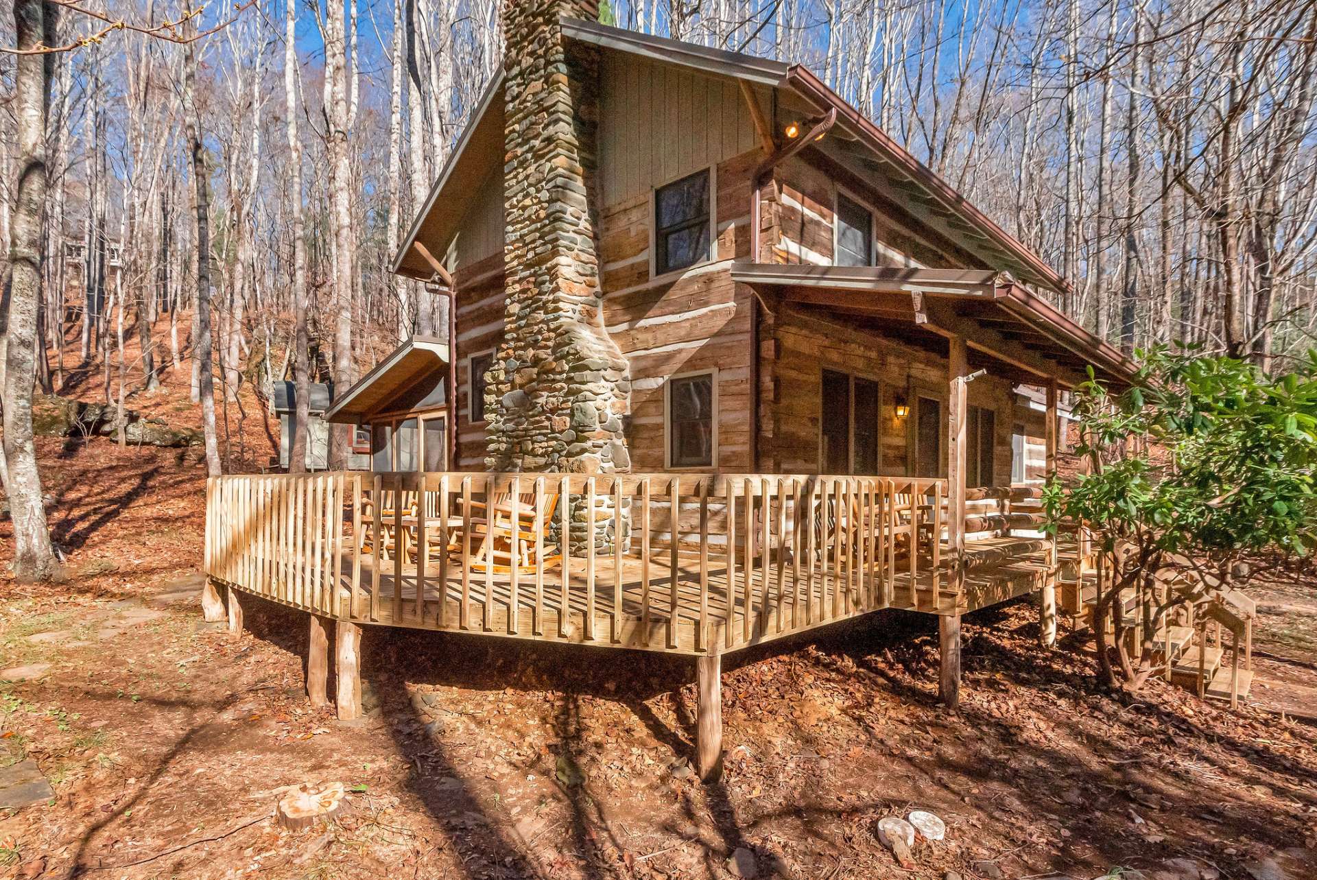 The expansive deck is perfect for morning coffee, relaxing in a rocking chair, or unwinding in a hammock while taking in the fresh mountain air and melodies of the rushing water.