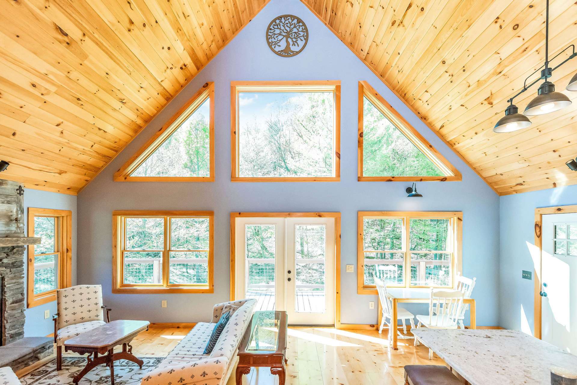 The wall of windows invites the natural light cascade throughout the  room.