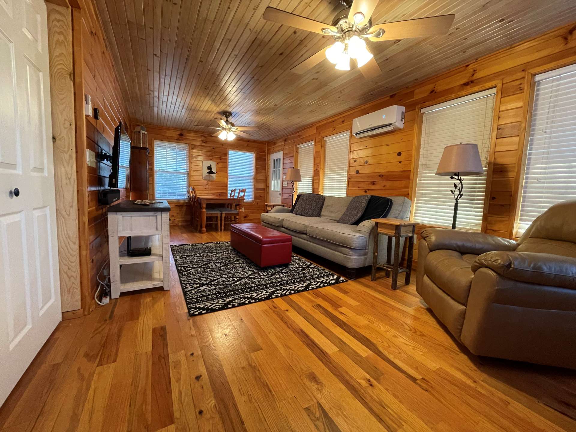 The living area has plenty of natural light with multiple windows all around.