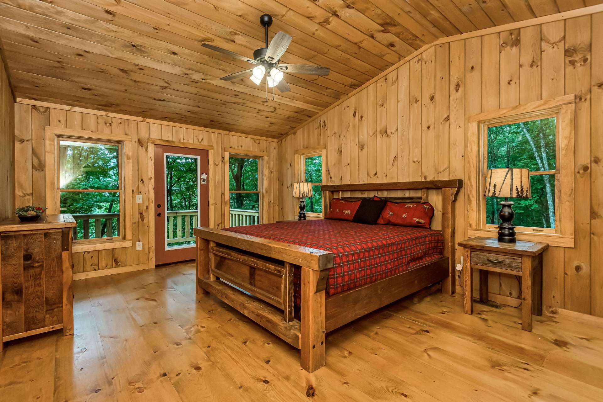 The primary bedroom on the main level offers a peaceful retreat and convenient access to the front deck, where an outdoor fireplace provides a perfect spot to unwind and enjoy the tranquil surroundings