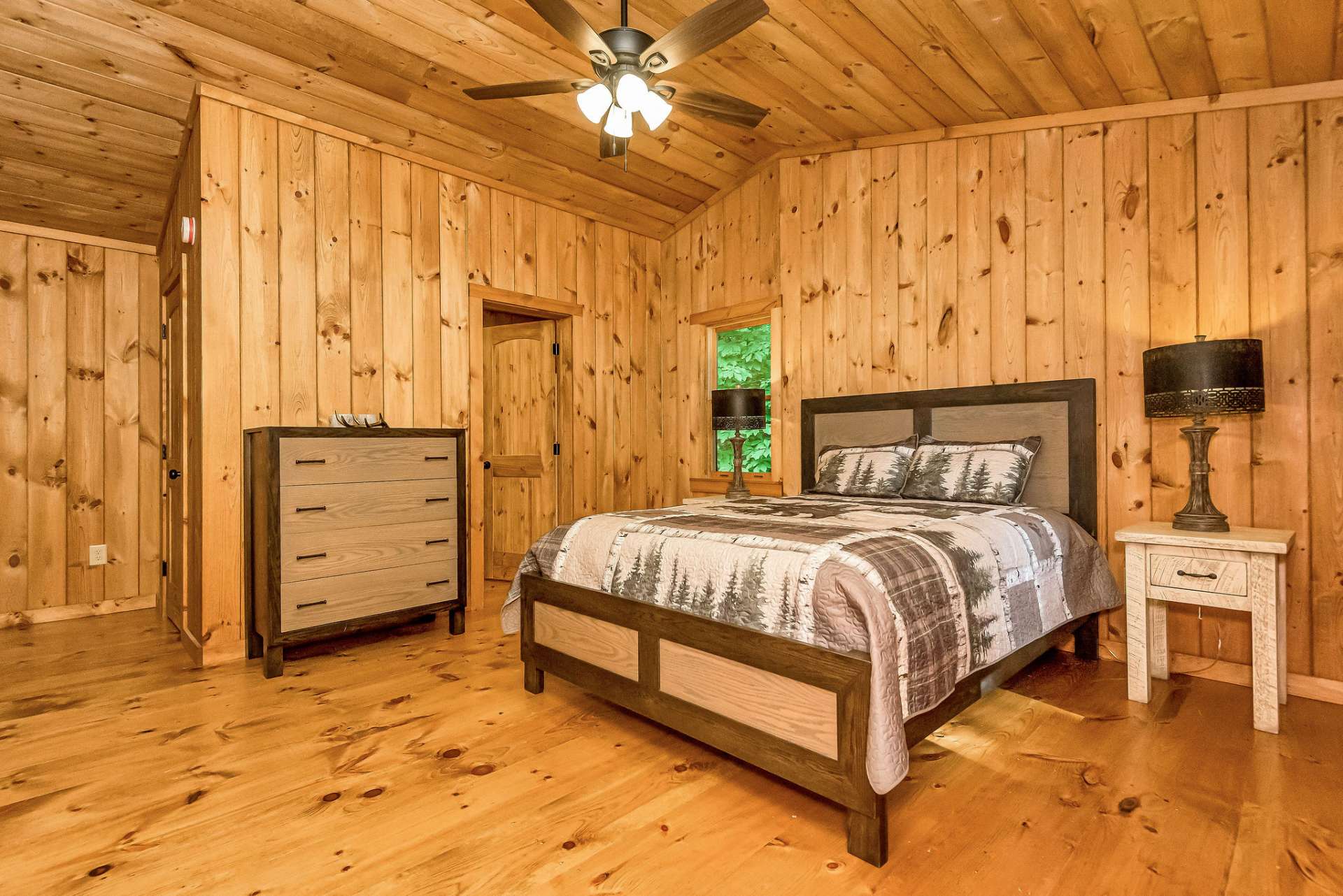 The loft maintains the charm of wide plank pine flooring and continues the cozy ambiance with tongue-and-groove walls and ceiling, echoing the rustic elegance found throughout the home.