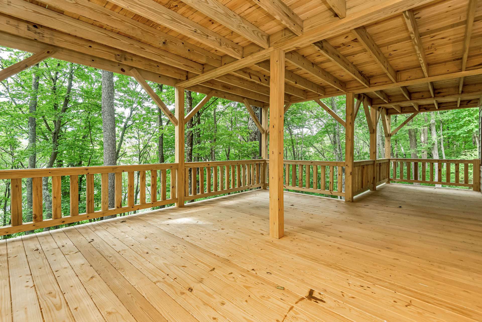 This expansive outdoor space provides a perfect setting for family or guests to immerse themselves in the fresh mountain air and soak in the tranquility of the surrounding lush forest.