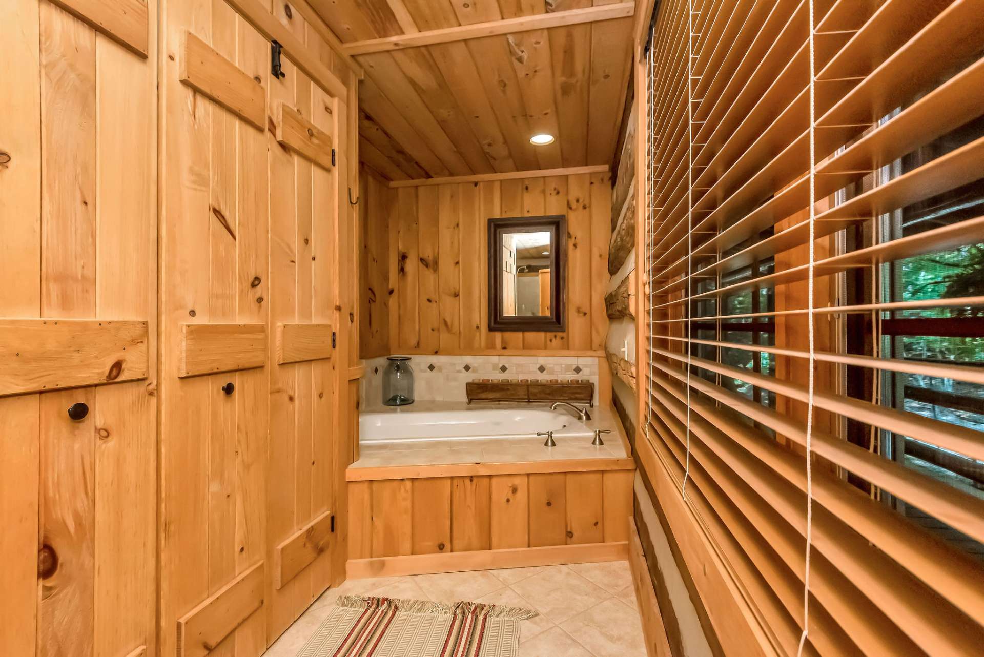 The primary bath also includes a luxurious soaking tub, ideal for unwinding after a long day. A full size washer and dryer are situated behind the double doors.