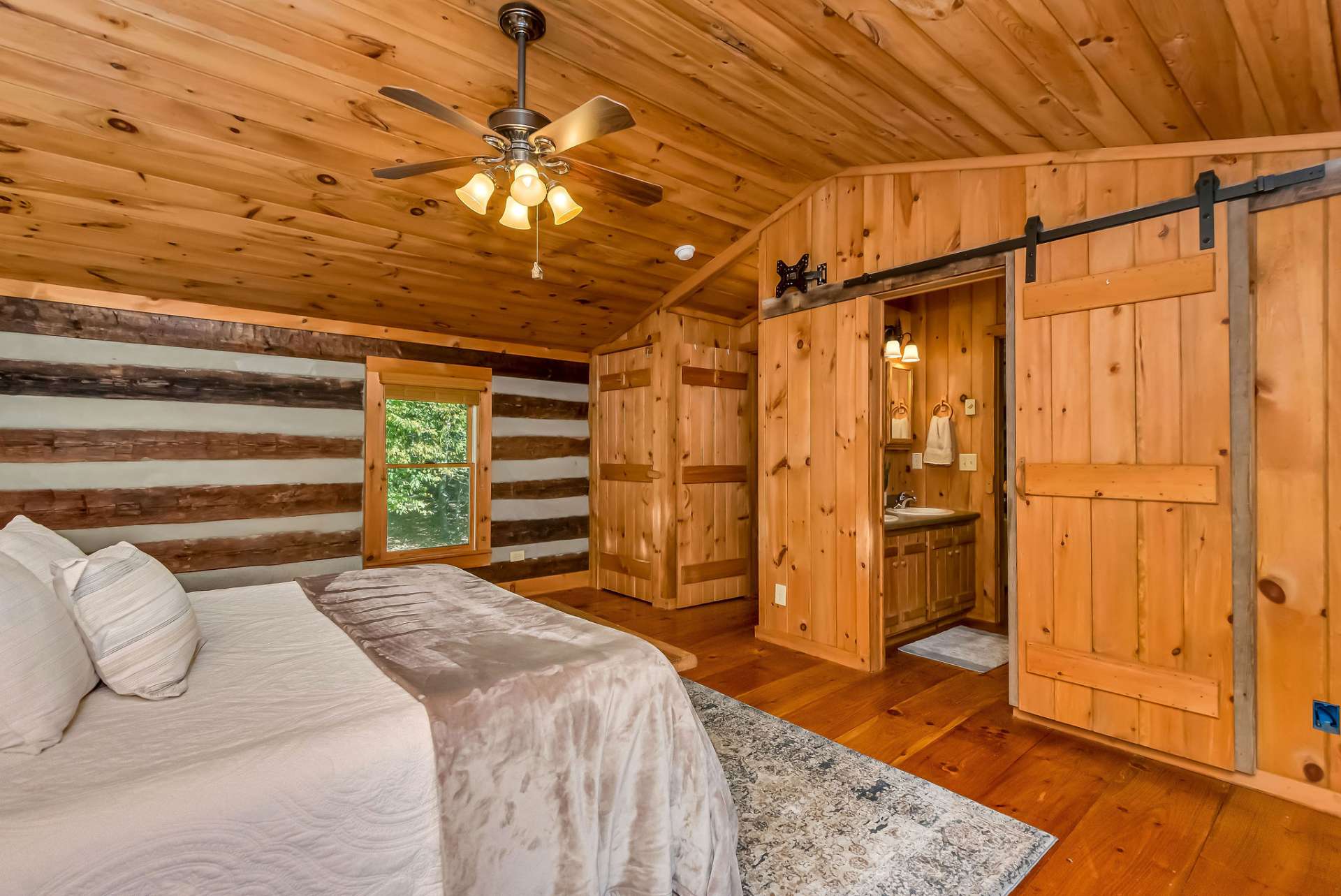 Access the ensuite bath through sliding barn doors, enhancing the rustic charm.