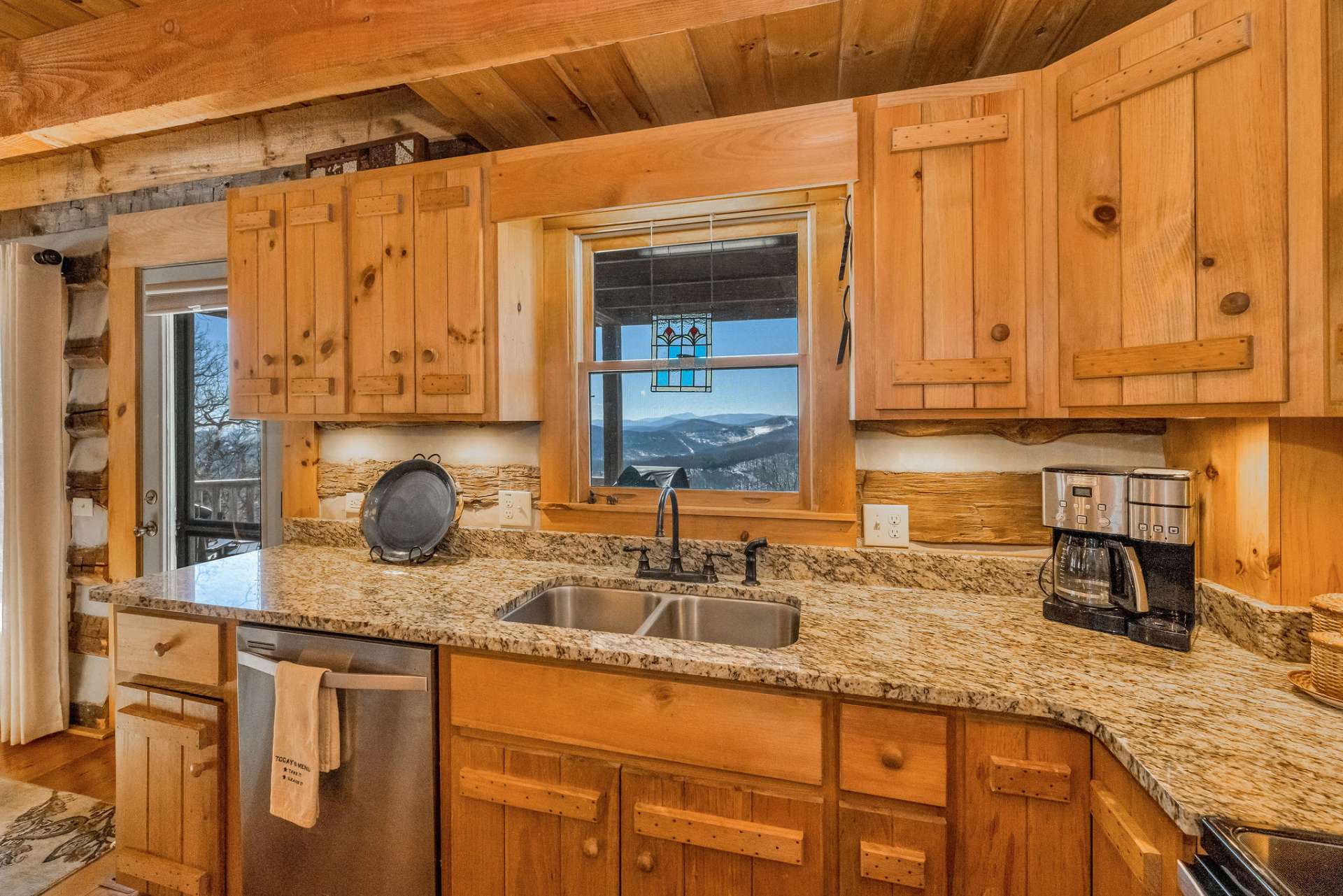 The kitchen boasts granite countertops and stainless appliances. Who wouldn't want to volunteer to wash dishes with that view?