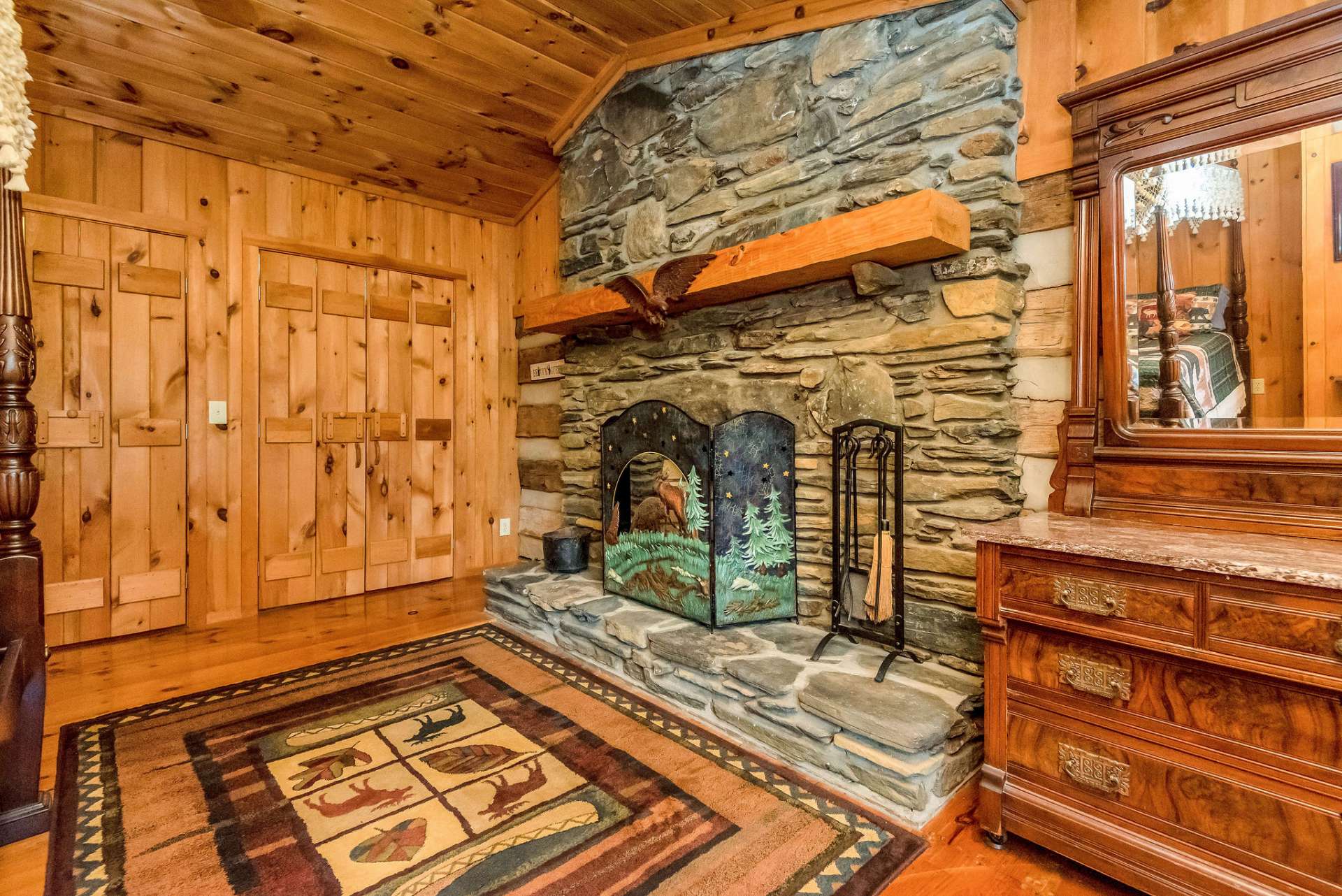 The allure of the stone fireplace in this guest room promises cozy evenings spent in timeless warmth.