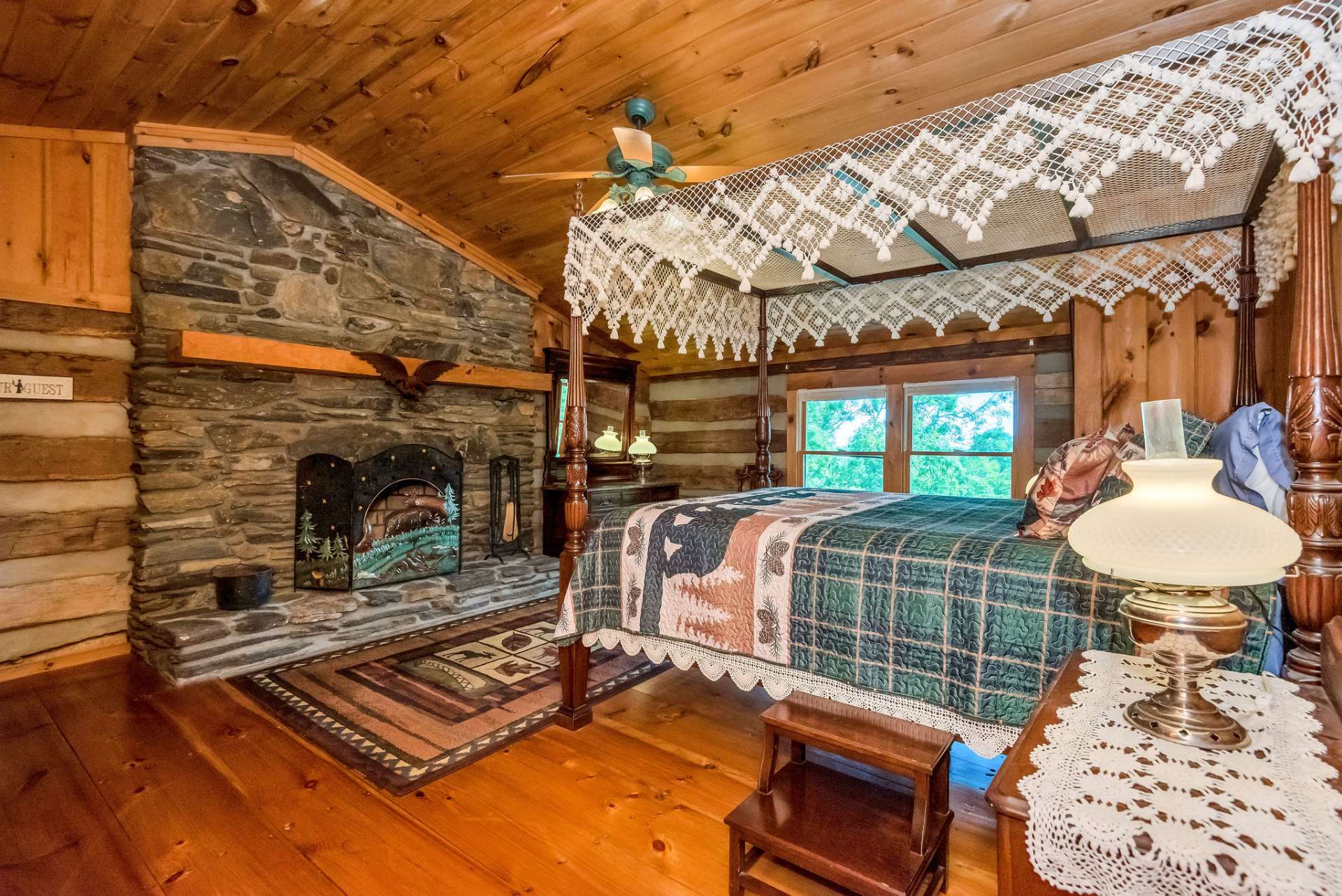 The first upper-level guest bedroom offers a wood-burning fireplace, vaulted ceilings, and view.